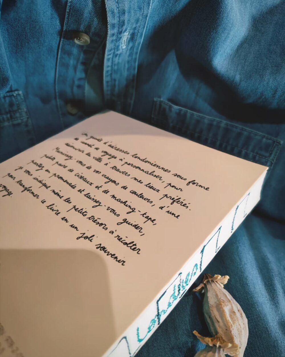 Texte manuscrit à l’arrière du carnet de voyage "Londres" sur fond de jean